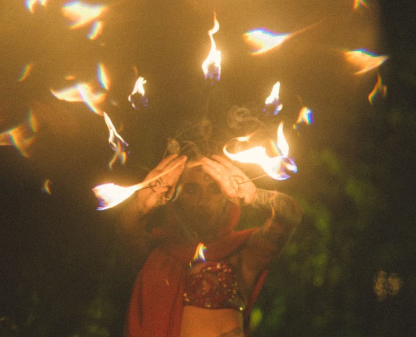 Performance con il fuoco durante un evento serale al The Sanctuary Eco Retreat Roma – atmosfera mistica immersa nella natura, tra arte, musica e spiritualità